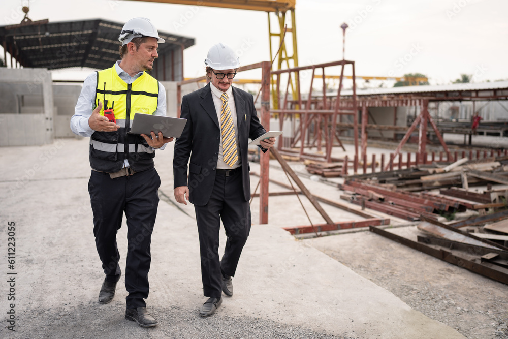 Fototapeta premium Portrait two caucasian engineer man working with notebook computer at precast site work 