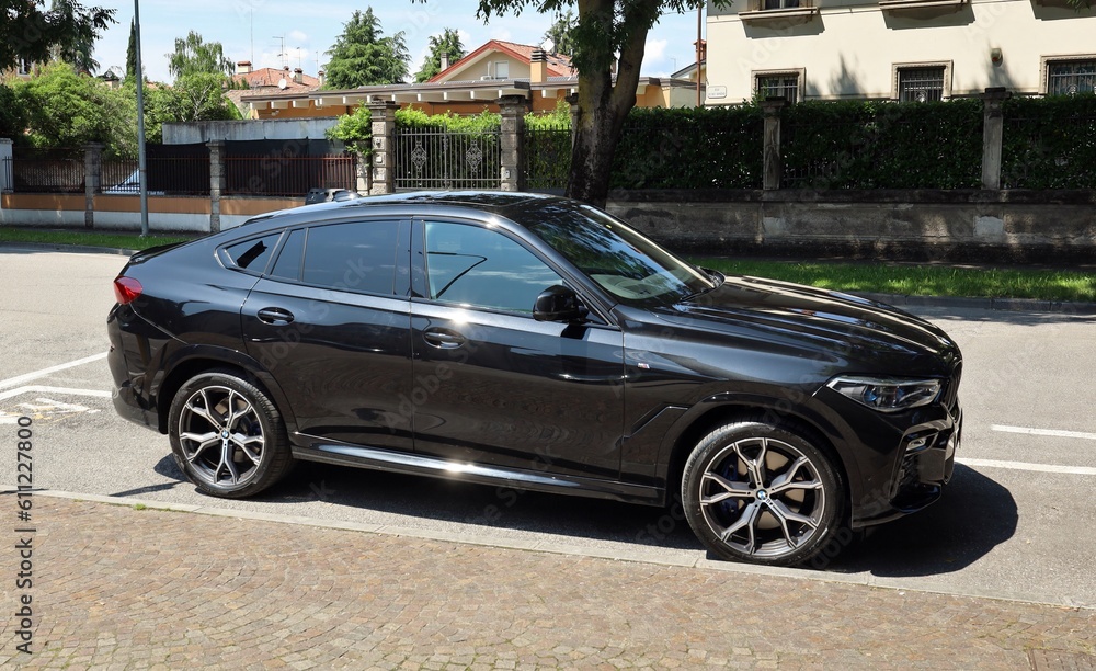 Udine, Italy. June 8, 2023.New black Bmw X6 parked at the roadside in a ...