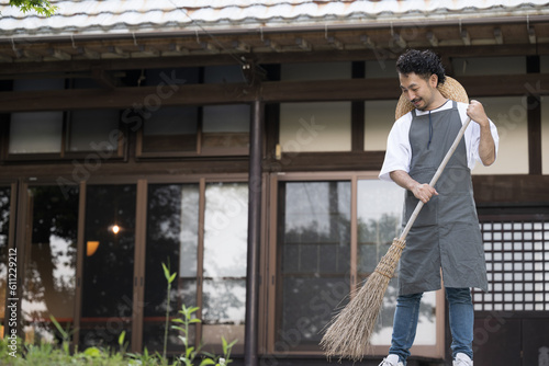 Wallpaper Mural 古民家や古い家の庭を掃除して手入れする男性 Torontodigital.ca