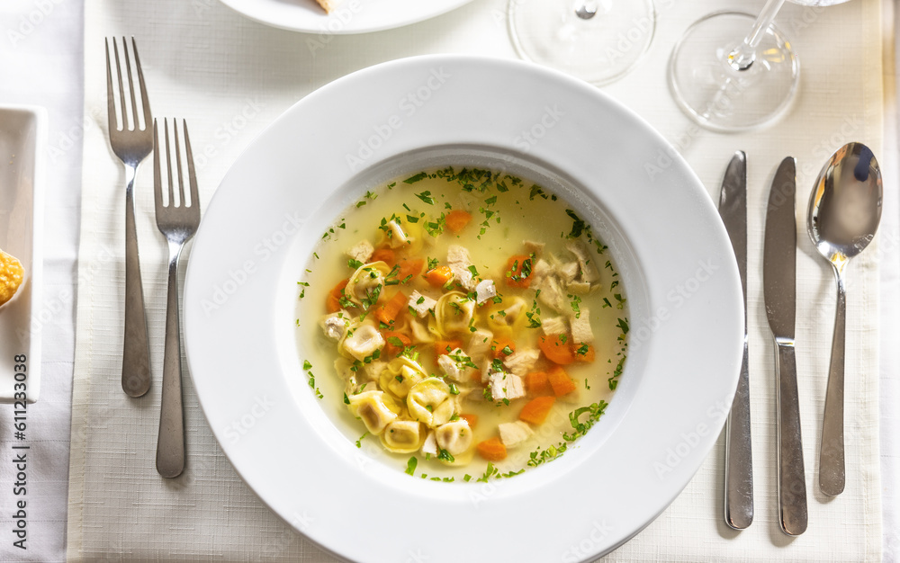 Top view of a chicken soup with tortelini served on a fancy table Top view of a chicken soup with tortelini served on a fancy table