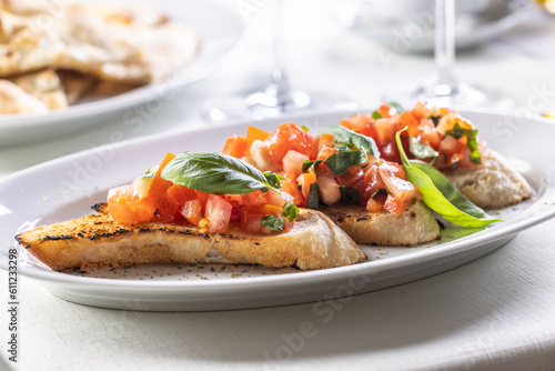 Detail of bruschetta on sourdough bread with chopped tomatoes and fresh basil leaves
