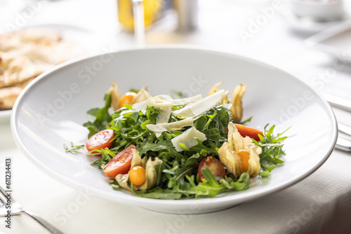 Ruccola salad with cherry tomatoes, physalis and parmesan cheese shavings