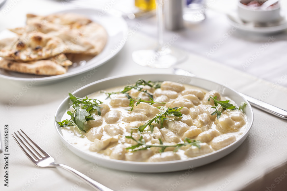 Italian gnocchi ai quatro formaggi with pizza bread on the side served on a table Italian gnocchi ai quatro formaggi with pizza bread on the side served on a table