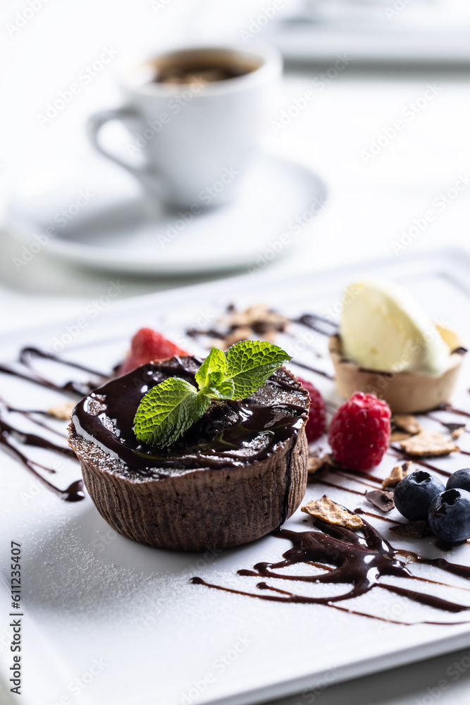 Brownies with ice cream and fruit, mint and chocolate decoration with an espresso on a cafe table Brownies with ice cream and fruit, mint and chocolate decoration with an espresso on a cafe table
