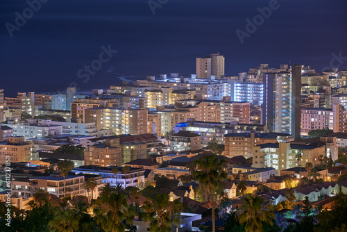 City, buildings and urban landscape at night, skyline and location with architecture, landmark and travel. Cityscape, skyscraper and Cape Town view for tourism, traveling and background destination