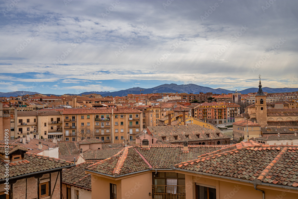 Panorama of the city center of Segovia with the moutains in the background and milky clouds