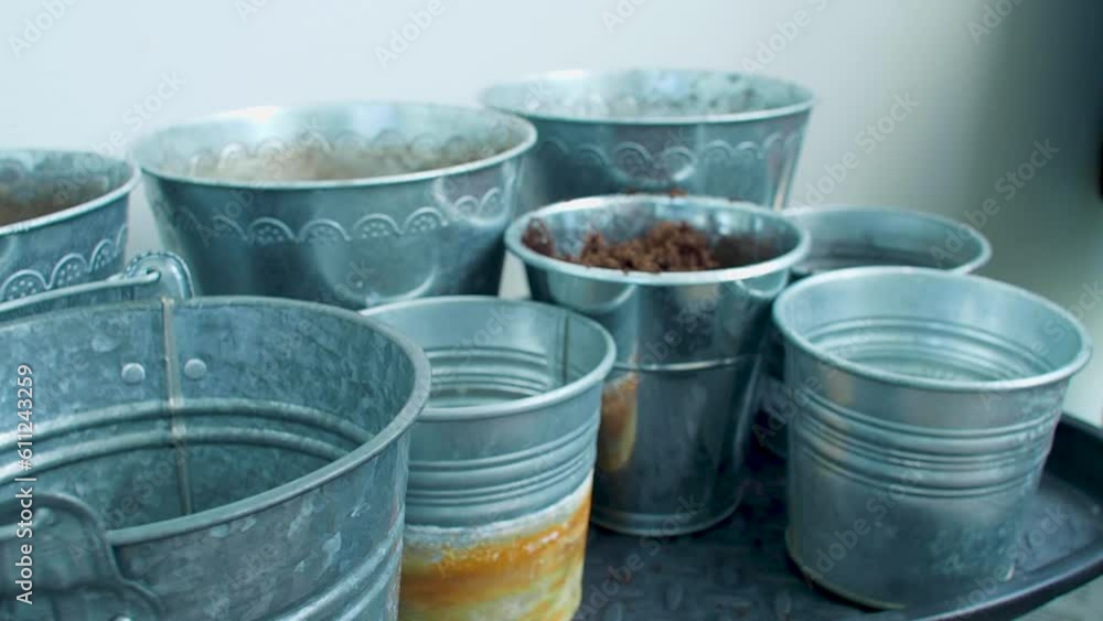 The buckets are being filled with soil, as the earth is spread or distributed across them. The buckets are being filled with soil, as the earth is spread or distributed across them.
