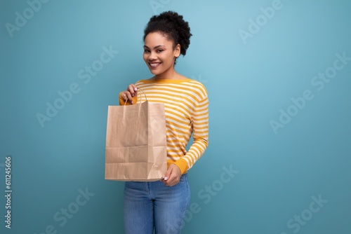 afro brunette latin young woman holding craft gift bag