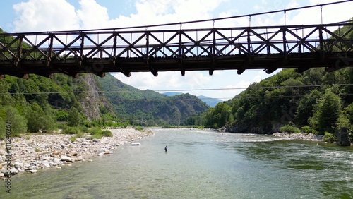 Drone flight over a wooden Tibetan suspended bridge that joins the river banks - view from the drone in Alagna Val Sesia Piedmont Alps mountains - travel concept journey in adventure natural trip  photo