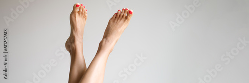 Tableau sur toile Female feet with red nails on white background closeup