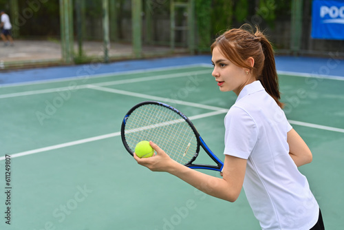 Image of pretty young female tennis player with racket serving ball during match © Prathankarnpap