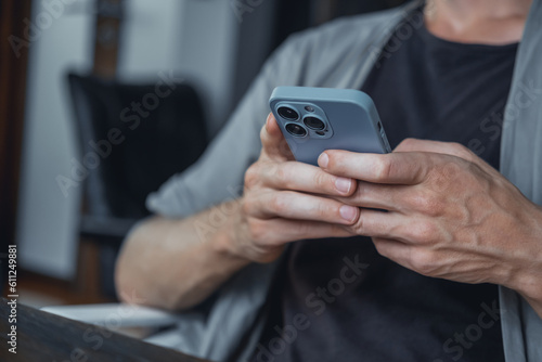 Young man using smartphone in hand, cafe, office,outdoor portrait business man, hipster style, internet, smartphone, office, Bali Indonesia, holding, mac OS, manager, freelancer, concept