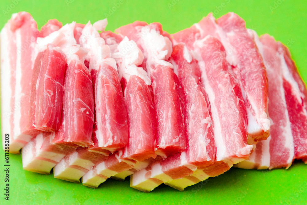 A few pieces of raw meat pork.A cut piece of pork close-up, fresh pork meat before baking,cooking.Green background.Closeup.