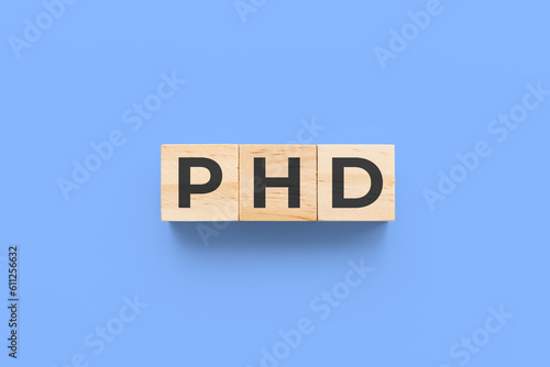 PHD (Doctor of Philosophy) wooden cubes on blue background