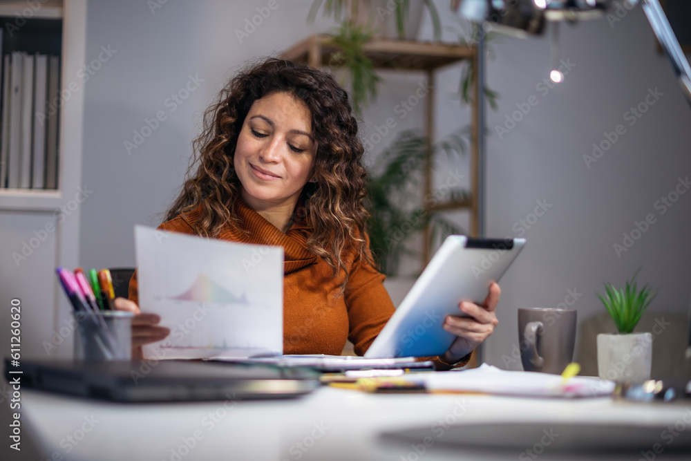 Attractive woman working on a tablet in a home office. Attractive woman working on a tablet in a home office.
