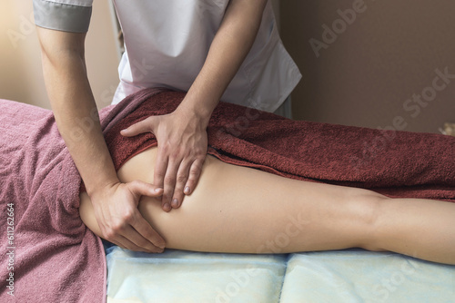 A male masseur makes a massage of the gluteal muscles and thighs to his client in a treatment room, a concept on the theme of body restoration and relieving fatigue