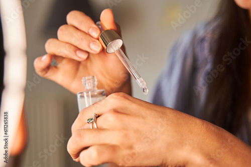 Cropped view of the caucasian woman hand applying face serum on her hand