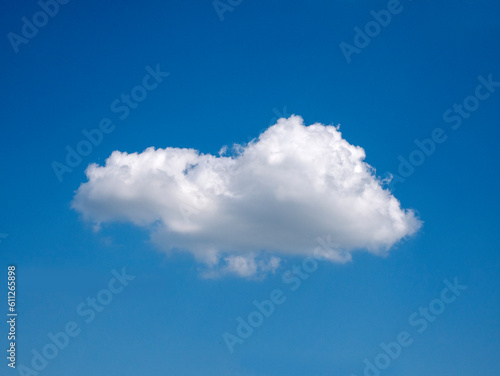 Single white cloud over blue sky background. Fluffy cloud shape photo