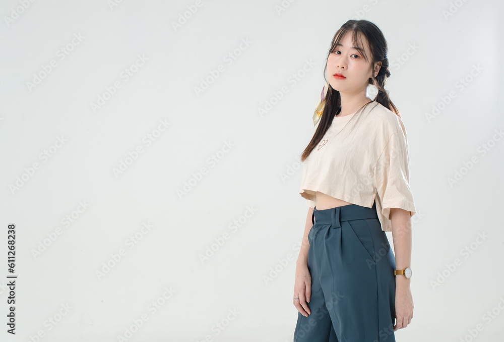 Portrait isolated cutout studio shot of Asian young cute female teenage fashion model with pigtails braids hairstyle in casual trendy wear standind posing look at camera on white background Portrait isolated cutout studio shot of Asian young cute female teenage fashion model with pigtails braids hairstyle in casual trendy wear standind posing look at camera on white background