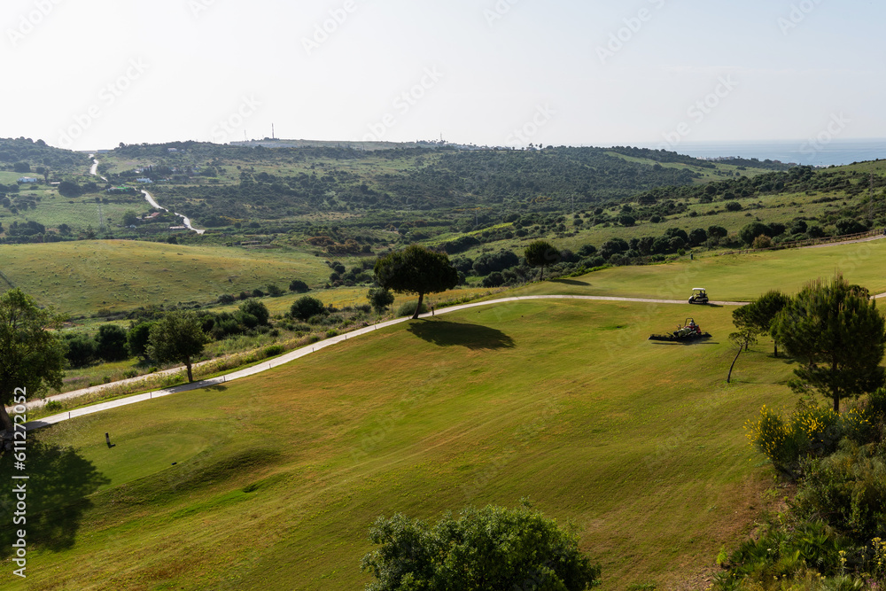 Obraz premium Golf course landscape, Spain. Picturesque scenery golf course green field with trees. Province of Alicante, Spain. Sport and lifestyle concept.