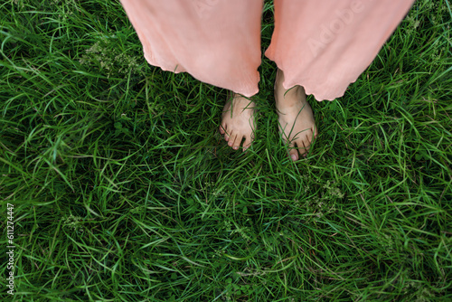 Bare feet of woman standing in lush green grass