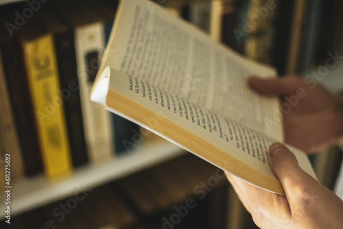 A girl is holding an old English fictional book with a private library on a background