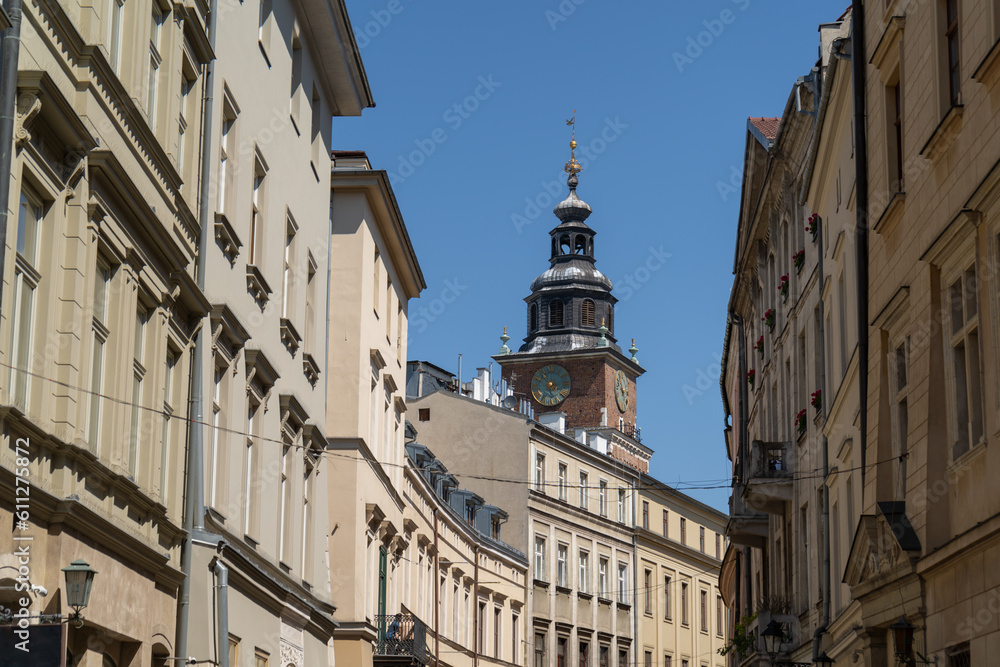 Bracka Street in the Old Town district of Krakow, Poland. View from Franciszkańska towards the Cracow Main Square Market. Town Hall Tower or Wieża Ratuszowa Kraków in background.