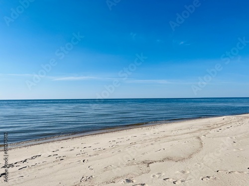 Blue sea horizon and white sandy coastline, wild empty sandy beach, blue sea horizon