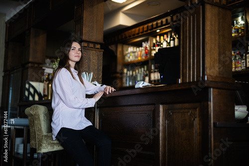 Young beautiful brunette woman sitting near bar counter.