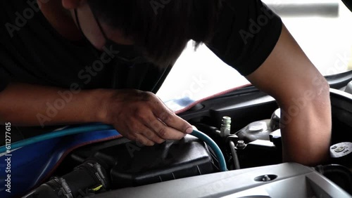 Asian mechanic checking car air conditioning system,Servicing car air conditioner.