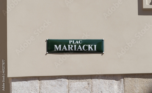 Plac Mariacki square, around Cracow St. Mary’s Basilica. Street name sign in the Old Town district of Krakow, Poland. Information plate on building wall in Kraków.