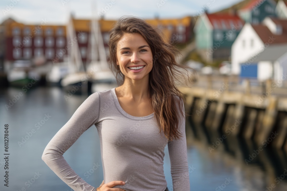 Lifestyle portrait photography of a grinning girl in her 30s wearing a versatile pair of leggings against a picturesque fishing village background. With generative AI technology