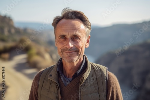 Close-up portrait photography of a glad mature man wearing a comfortable pair of jeggings against a scenic canyon background. With generative AI technology