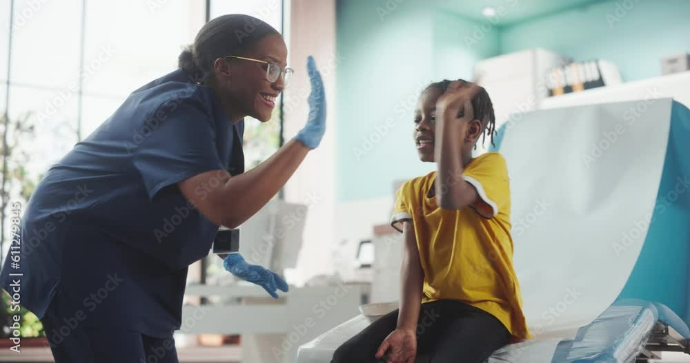 African American Boy Sitting In The Chair In Bright Hospital. Female Black Nurse Putting Patch On A Kid After Polio Vaccine Injection. Professional Woman High-Five Young Man For Not Being Scared. African American Boy Sitting In The Chair In Bright Hospital. Female Black Nurse Putting Patch On A Kid After Polio Vaccine Injection. Professional Woman High-Five Young Man For Not Being Scared.