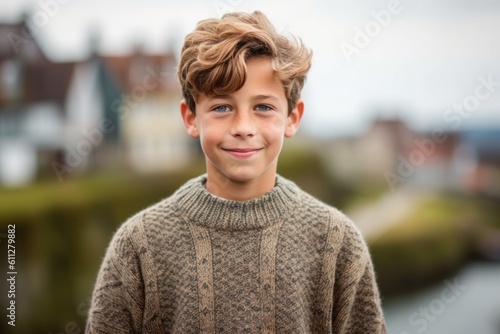 Close-up portrait photography of a grinning mature boy wearing a cozy sweater against a scenic cliffside village background. With generative AI technology