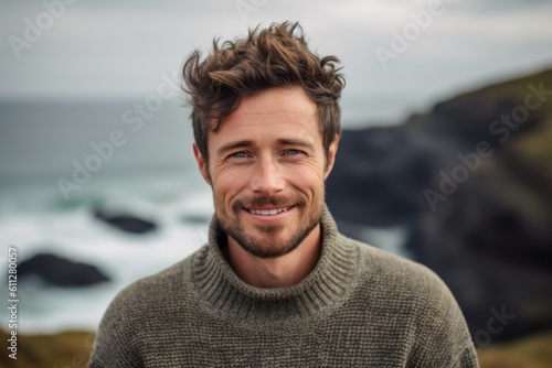Close-up portrait photography of a satisfied boy in his 30s wearing a cozy sweater against a scenic ocean cliff background. With generative AI technology