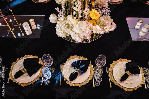 Luxury golden rich decor. Plate decorated napkin, cutlery, glasses. Serving, setting table. Wedding set up, dinner reception. Birthday, baptism, event. Festive tables with flowers, candles. Top view.