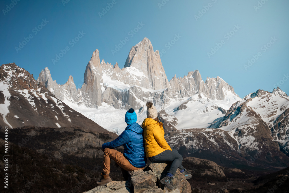 Fototapeta premium Travelers couple in love enjoying the view of majestic Mount Fitz Roy - symbol of Patagonia, Argentina