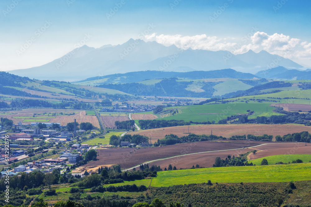 slovakia countryside in summertime. high tatra ridge in the distance. clouds on the blue sky