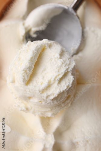 Scoop of delicious vanilla ice cream in container, closeup