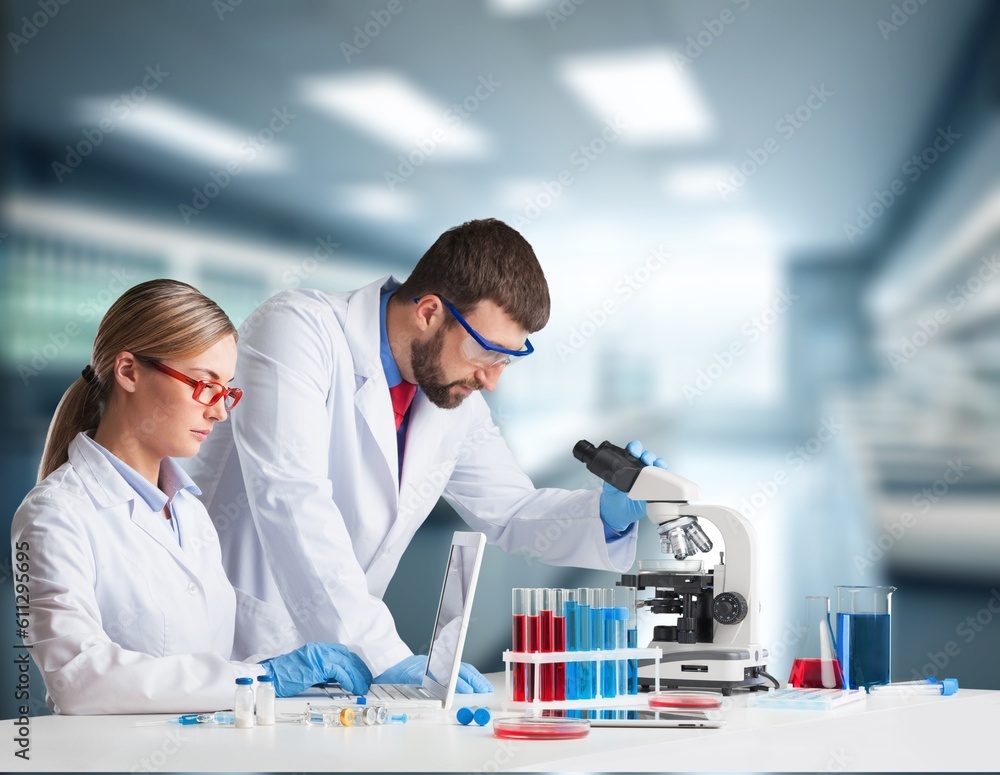 Smiling scientists work in modern laboratory Smiling scientists work in modern laboratory