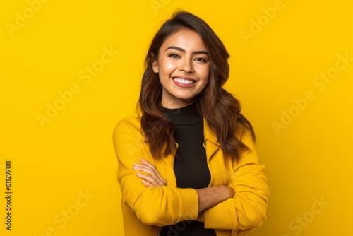 Medium shot portrait photography of a grinning girl in her 20s crossing the arms against a bright yellow background. With generative AI technology © Markus Schröder