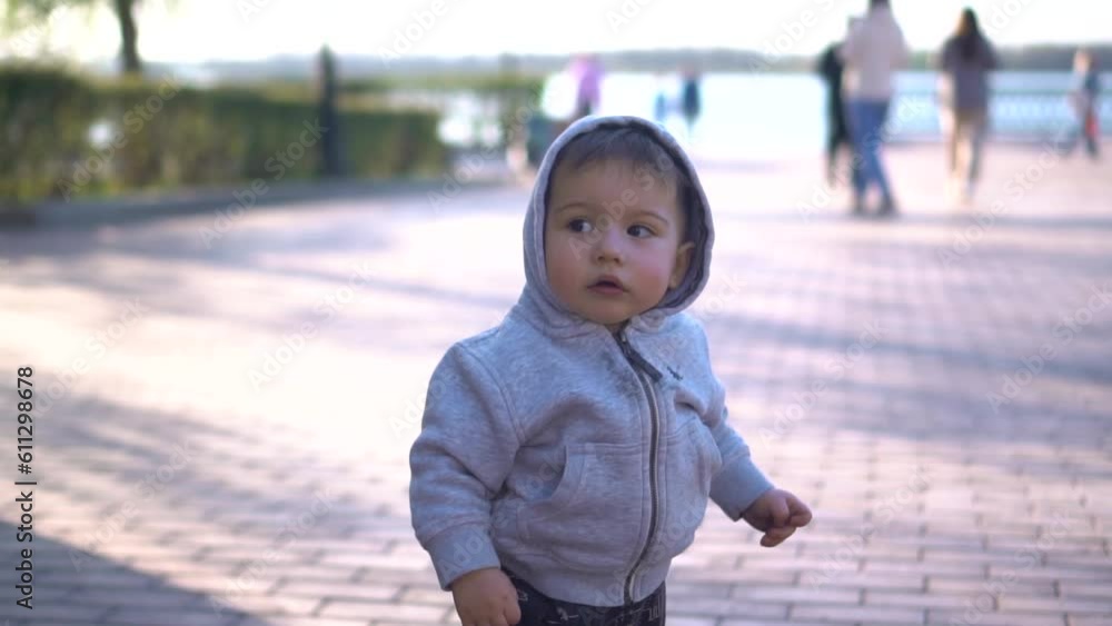 Thoughtful child. A one-year-old boy in a hood walks in the park. Slow motion. Thoughtful child. A one-year-old boy in a hood walks in the park. Slow motion.