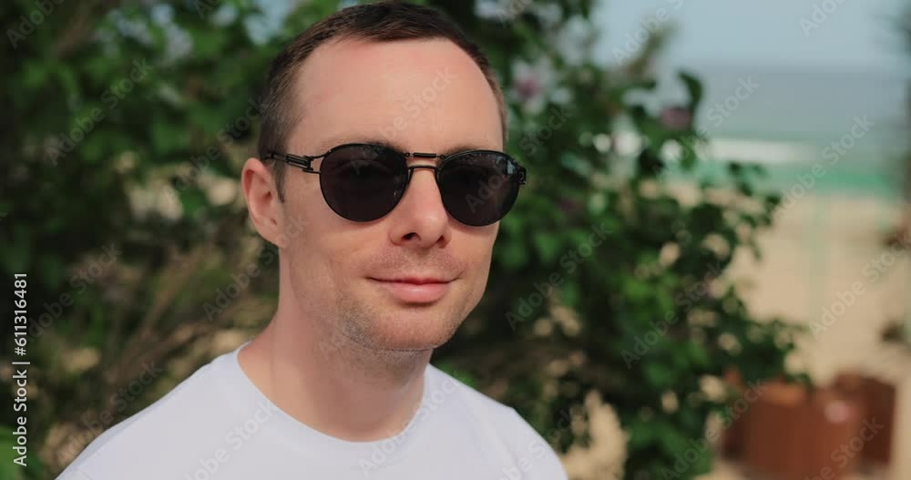 Closeup smiling man in sunglasses turn a face Closeup smiling man in sunglasses turn a face