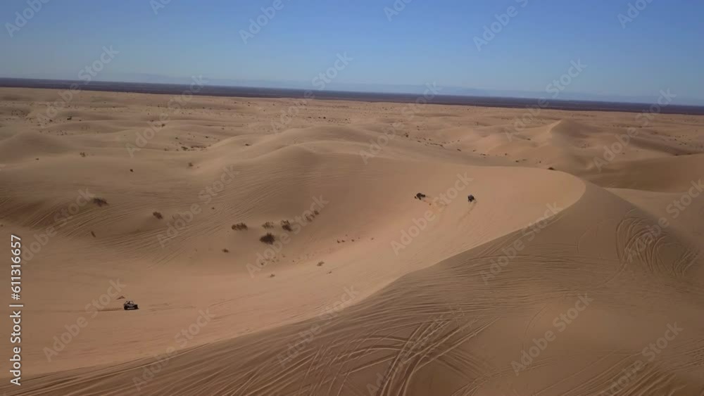 Aerial Shot Of Dune Buggies On Sand Dunes In Desert Against Sky, Drone Flying Forward Over Landscape - Glamis, California Aerial Shot Of Dune Buggies On Sand Dunes In Desert Against Sky, Drone Flying Forward Over Landscape - Glamis, California
