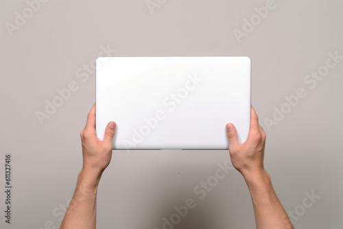 Blank closed laptop in a male hands. AI generated