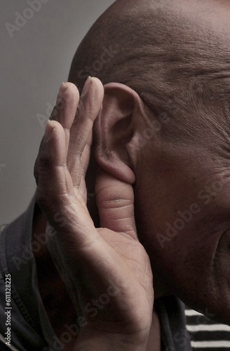 deaf man suffering from deafness and hearing loss on grey background with people stock image stock photo photo