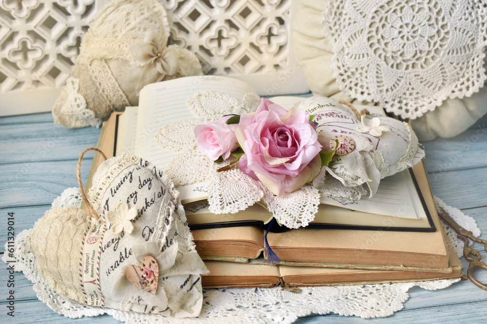 Romantic style arrangement with old books and handicraft textile hearts on the table Romantic style arrangement with old books and handicraft textile hearts on the table