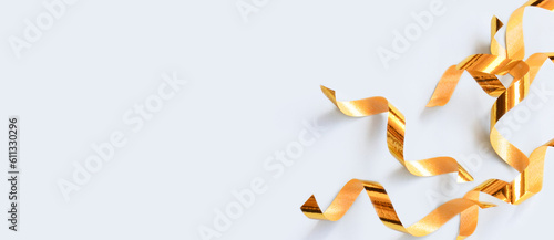 Banner with golden ribbons confetti on a blue background. Composition with copy space.