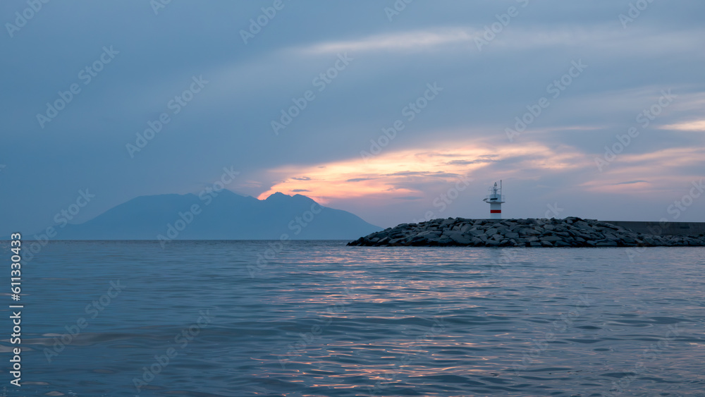 Sunset, Greek island Samothrace and lighthouse view at Gokceada Kalekoy location. Imbros island Canakkale, Turkey Sunset, Greek island Samothrace and lighthouse view at Gokceada Kalekoy location. Imbros island Canakkale, Turkey